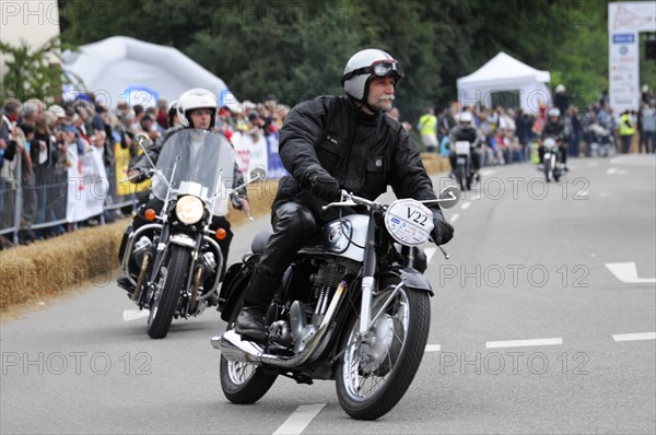 A motorcyclist wearing a helmet rides on a road, surrounded by spectators, SOLITUDE REVIVAL 2011, Stuttgart, Baden-Wuerttemberg, Germany, Europe