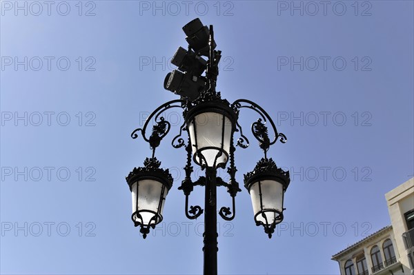 Granada, An ornate wrought iron street lamp against a clear blue sky, Granada, Andalusia, Spain, Europe
