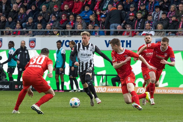 Football match, Robin HACK Borussia Moenchengladbach centre on the ball seems unstoppable, Norman THEUERKAUF left, Jan SCHOePPNER and captain Patrick MAINKA all 1.FC Heidenheim right in waiting, Voith-Arena football stadium, Heidenheim