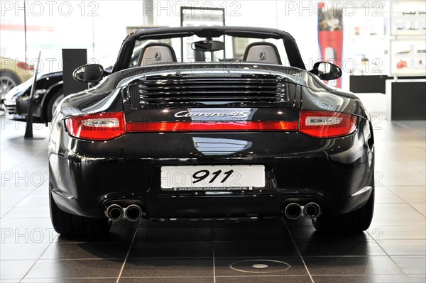 Rear view of a black Porsche Carrera 4S Cabriolet with the number 911, Schwaebisch Gmuend, Baden-Wuerttemberg, Germany, Europe
