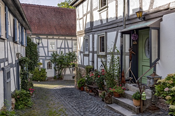 Old half-timbered houses, decorated with flowers, idyllic alley, old town, Ortenberg, Vogelsberg, Wetterau, Hesse, Germany, Europe