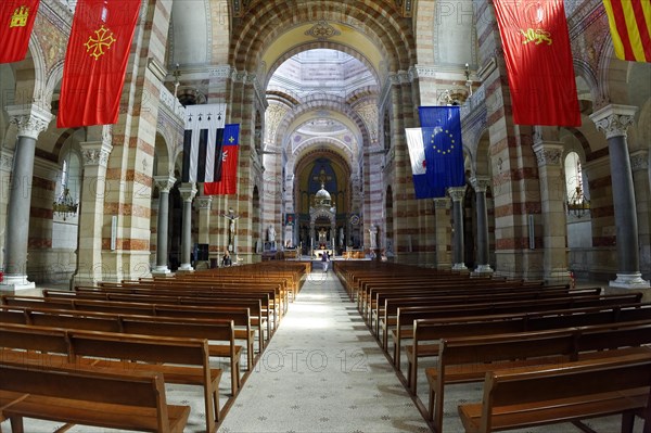 Marseille Cathedral or Cathedrale Sainte-Marie-Majeure de Marseille, 1852-1896, Marseille, Long view through the nave with flags and symmetrical architecture, Marseille, Departement Bouches-du-Rhone, Region Provence-Alpes-Cote d'Azur, France, Europe
