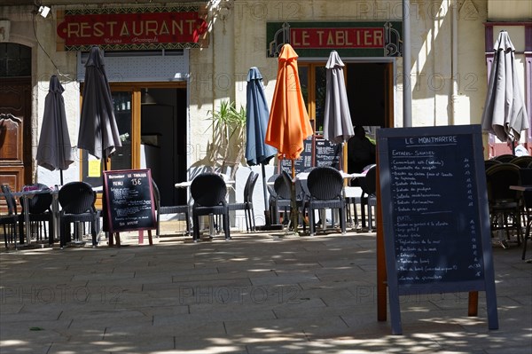 Marseille, Empty street cafe with closed parasols and a menu board next to it, Marseille, Departement Bouches-du-Rhone, Region Provence-Alpes-Cote d'Azur, France, Europe