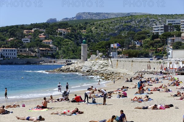 The bay of Port Miou in Cassis, people sunbathing on the beach with a view of the sea and nature, Marseille, Departement Bouches-du-Rhone, Region Provence-Alpes-Cote d'Azur, France, Europe