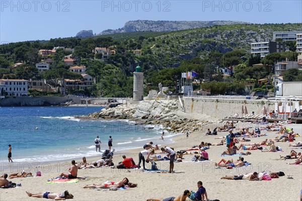 The bay of Port Miou in Cassis, people sunbathing on the beach with a view of the sea and nature, Marseille, Departement Bouches-du-Rhone, Region Provence-Alpes-Cote d'Azur, France, Europe