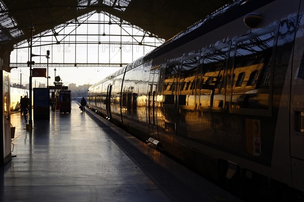 Marseille-Saint-Charles railway station, Marseille, Reflection of the evening sun on a train in a station with people, Marseille, Departement Bouches-du-Rhone, Region Provence-Alpes-Cote d'Azur, France, Europe