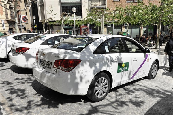 Jaen, row of white taxis waiting for passengers in a city street, Jaen, Andalusia, Spain, Europe