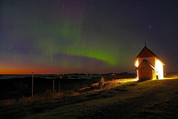 Northern lights (aurora borealis) merging with sunset, Petter Dass Chapel, night shot, Lovunden, Helgeland coast, Traena, Norway, Europe