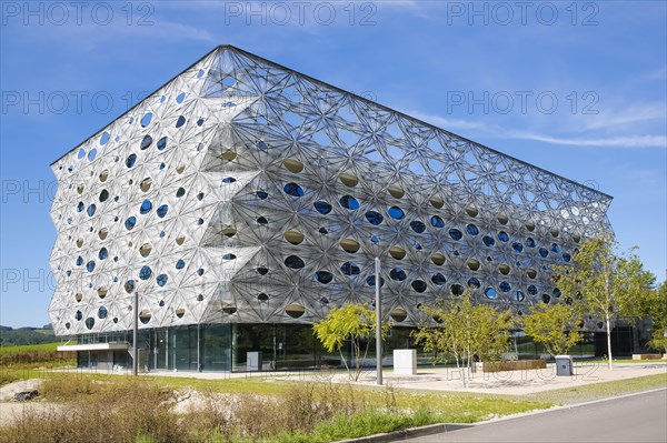 Reutlingen University, Reutlingen University, Texoversum, German University Building Award 2024 for TEXOVERSUM, modern architecture, facade made of carbon and glass fibres, mesh, innovative, identity-creating, unique facade, campus, place of learning, special, extraordinary new building for textile courses, light, airy, airy, holes, architectural eye-catcher, university campus, lights, street, young trees, blue sky, Reutlingen, Baden-Wuerttemberg, Germany, Europe