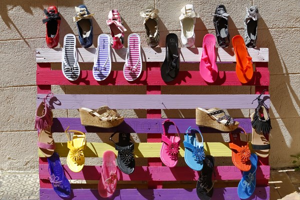 The bay of Port Miou in Cassis, A colourful bench with different shoes displayed in the sunlight, Marseille, Departement Bouches-du-Rhone, Region Provence-Alpes-Cote d'Azur, France, Europe