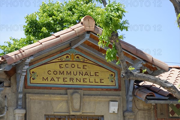 Marseille, sign of the Ecole Communale Maternelle with a tree and traditional architectural elements, Marseille, Departement Bouches-du-Rhone, Provence-Alpes-Cote d'Azur region, France, Europe