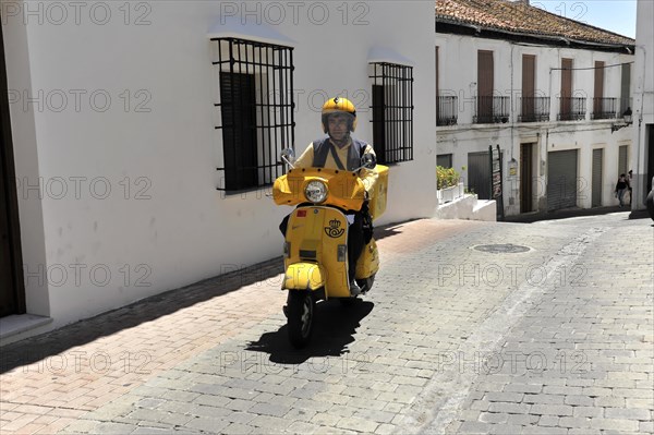 Solabrena, A yellow postal scooter on a road, a symbol for mobile mail delivery, Andalusia, Spain, Europe