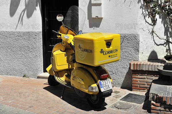 Solabrena, A yellow Correos scooter is parked and ready for mail delivery in Spain, Andalusia, Spain, Europe