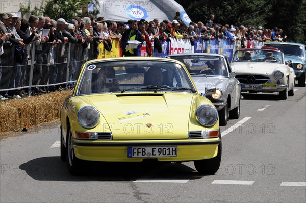 A yellow Porsche 911 classic car takes part in a street race with a view of the crowd, SOLITUDE REVIVAL 2011, Stuttgart, Baden-Wuerttemberg, Germany, Europe