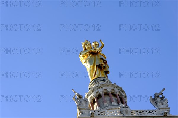 Church of Notre-Dame de la Garde, Marseille, Golden statue with raised hands on cathedral under blue sky, Marseille, Departement Bouches-du-Rhone, Region Provence-Alpes-Cote d'Azur, France, Europe
