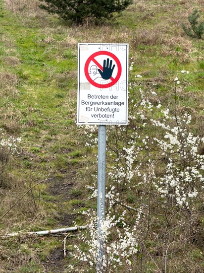 Prohibition sign with logo and inscription Unauthorised persons must not enter the mine site at the foot of the green former Schoettelheide slag heap, Bottrop, North Rhine-Westphalia, Germany, Europe