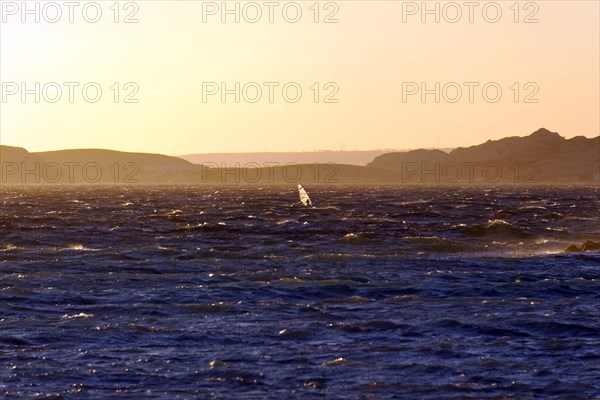 Marseille in the evening, A windsurfer glides over the ocean waves at sunset, Marseille, Departement Bouches-du-Rhone, Region Provence-Alpes-Cote d'Azur, France, Europe