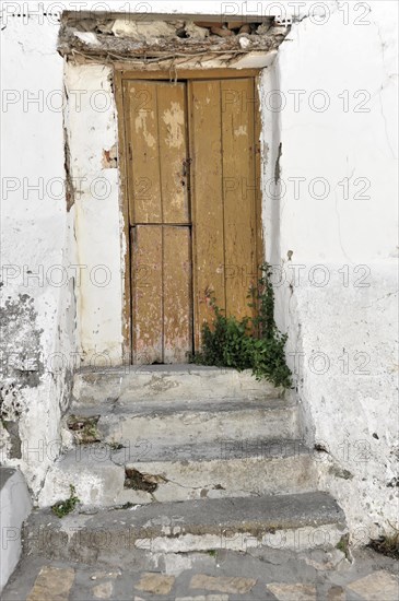 Solabrena, An old, dilapidated door with peeling brown paint, surrounded by a wall and steps, Andalusia, Spain, Europe