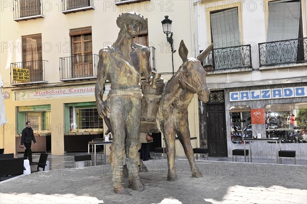 Granada, bronze statues of a man with a donkey on a busy street, Granada, Andalusia, Spain, Europe