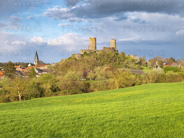 View of Muenzenberg town and castle in the Wetterau under dark clouds in spring evening light, Muenzenberg, Wetterau, Hesse, Germany, Europe