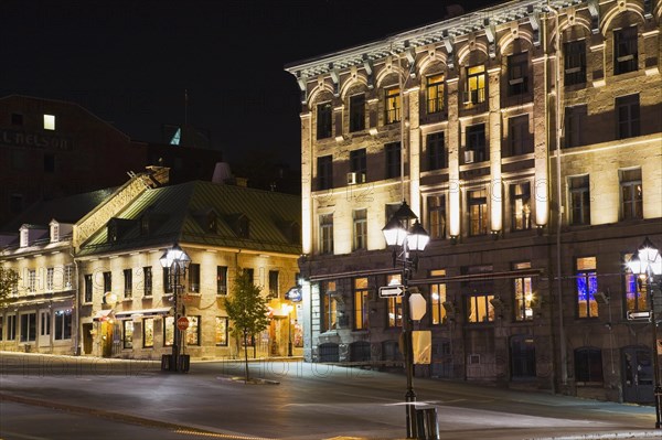 Old architectural style commercial and residential buildings illuminated at night on deserted Place Jacques Cartier in autumn, Old Montreal, Quebec, Canada, North America