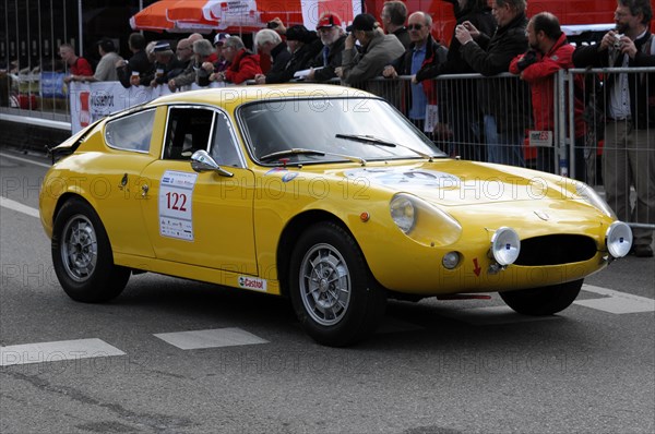 A classic yellow sports car drives past spectators during a road race, SOLITUDE REVIVAL 2011, Stuttgart, Baden-Wuerttemberg, Germany, Europe