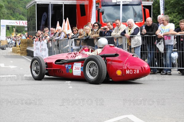 A classic red racing car drives in a street race, watched by spectators during the day, SOLITUDE REVIVAL 2011, Stuttgart, Baden-Wuerttemberg, Germany, Europe