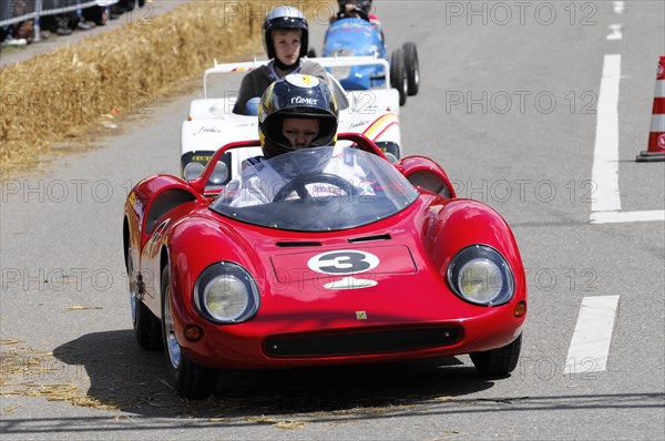 A racing driver in a red sports car during a race with spectators in the background, SOLITUDE REVIVAL 2011, Stuttgart, Baden-Wuerttemberg, Germany, Europe