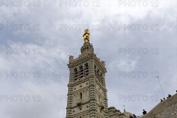 Madonna, Church of Notre-Dame de la Garde, Marseille, A tall church tower with a gold-coloured statue at the top under a cloudy sky, Marseille, Departement Bouches-du-Rhone, Madonna, Church of Notre-Dame de la Garde, Marseille, Provence-Alpes-Cote d'Azur region, France, Europe