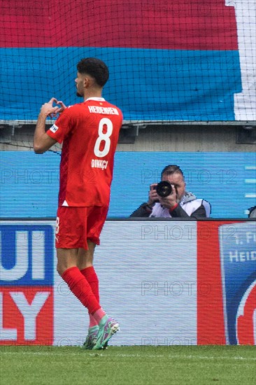 Football match, Eren DINKCI 1.FC Heidenheim has just scored the 1 to 1 equaliser and has given his heart to the Heidenheim fans, Voith-Arena football stadium, Heidenheim