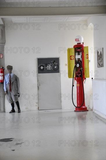 Deutsches Automuseum Langenburg, Old red Shell petrol pump next to a motorbike replica in a museum, Deutsches Automuseum Langenburg, Langenburg, Baden-Wuerttemberg, Germany, Europe