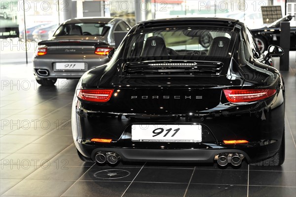 The rear view of a shiny black Porsche 911 in a car dealership, Schwaebisch Gmuend, Baden-Wuerttemberg, Germany, Europe