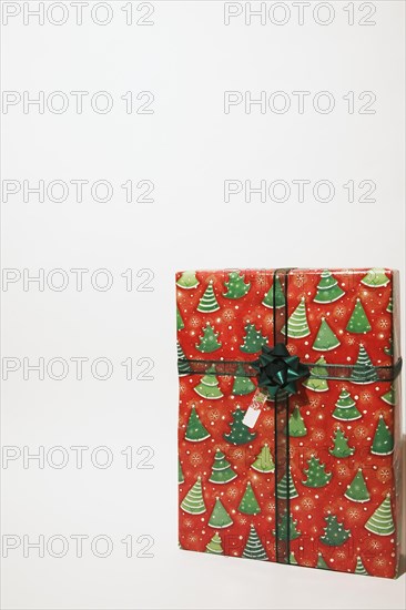 Close-up of box shaped Christmas gift wrapped with red and green wrapping paper on white background, Studio Composition, Quebec, Canada, North America