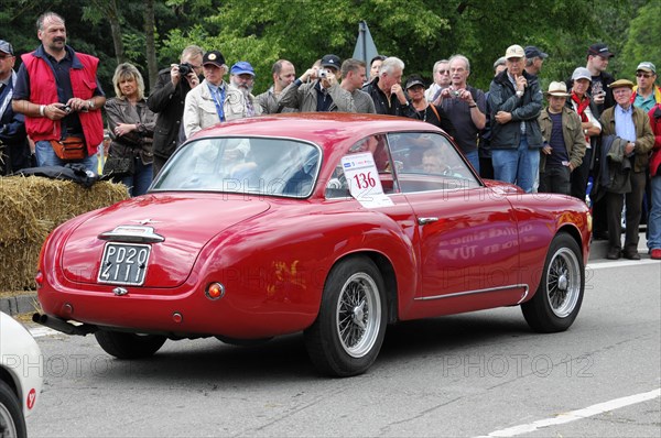 A red vintage sports car drives in front of a crowd at a classic car race, SOLITUDE REVIVAL 2011, Stuttgart, Baden-Wuerttemberg, Germany, Europe
