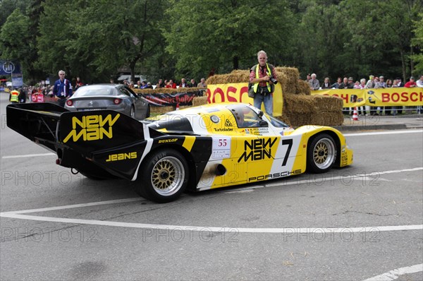 A yellow Porsche racing car next to straw bales on the race track, driver standing next to it, SOLITUDE REVIVAL 2011, Stuttgart, Baden-Wuerttemberg, Germany, Europe