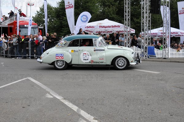 A green vintage car with sponsor logos drives past a crowd at a rally, SOLITUDE REVIVAL 2011, Stuttgart, Baden-Wuerttemberg, Germany, Europe