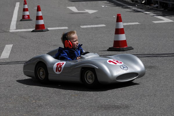 Child concentrates while driving a racing soapbox on a road course, SOLITUDE REVIVAL 2011, Stuttgart, Baden-Wuerttemberg, Germany, Europe