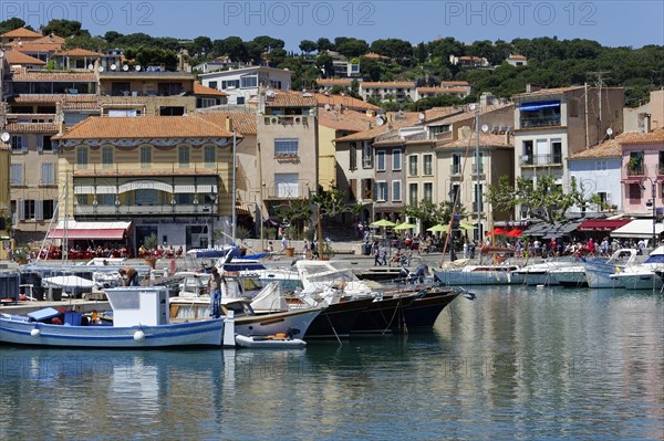 Cassis, the harbour, Colourful houses and cafes along a harbour with boats under a clear sky, Marseille, Departement Bouches-du-Rhone, Region Provence-Alpes-Cote d'Azur, France, Europe