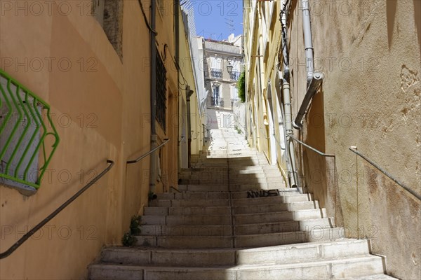 Marseille, Narrow alley with stairs between old buildings on a sunny day, Marseille, Departement Bouches-du-Rhone, Region Provence-Alpes-Cote d'Azur, France, Europe