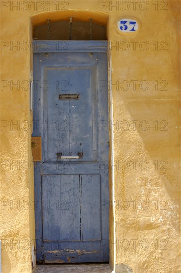 Marseille, Old faded blue door in a yellow plaster facade with the house number 37, Marseille, Departement Bouches-du-Rhone, Region Provence-Alpes-Cote d'Azur, France, Europe