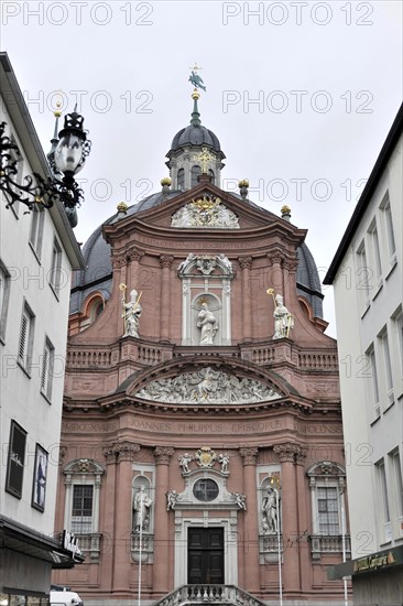 Neumuenster Collegiate Abbey, Diocese of Wuerzburg, red baroque church facade with sculptures, central dome and a clock, Wuerzburg, Lower Franconia, Bavaria, Germany, Europe
