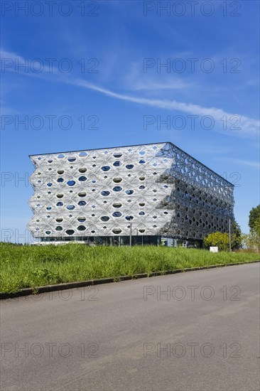 Reutlingen University, Reutlingen University, Texoversum, German University Building Award 2024 for TEXOVERSUM, modern architecture, facade made of carbon and glass fibres, mesh, innovative, identity-creating, unique facade, campus, place of learning, special, extraordinary new building for textile courses, light, airy, airy, holes, architectural eye-catcher, university campus, lights, street, young trees, blue sky, meadow, lawn, Reutlingen, Baden-Wuerttemberg, Germany, Europe