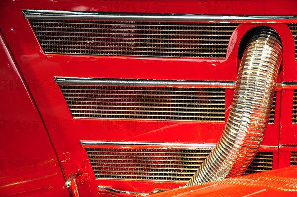 Close-up of the radiator grille of a red classic car with striking chrome details, Mercedes-Benz Museum, Stuttgart, Baden-Wuerttemberg, Germany, Europe
