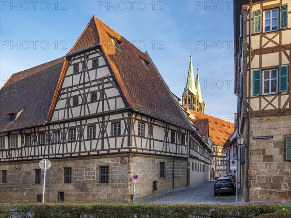 Alley with half-timbered houses and cobblestones, in the background the towers of Bamberg Cathedral in the evening light, Bamberg, Upper Franconia, Bavaria, Germany, Europe