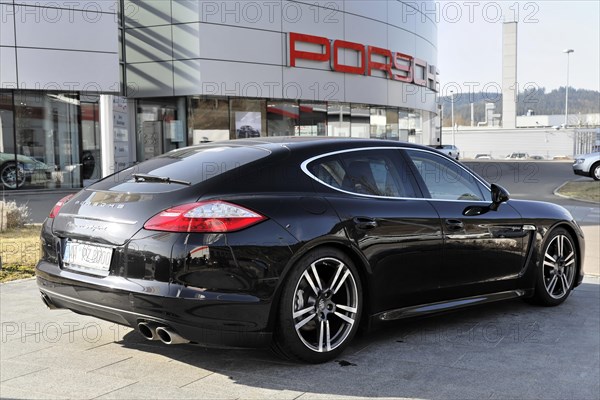 Side view of a black Porsche Panamera outside a car dealership, Schwaebisch Gmuend, Baden-Wuerttemberg, Germany, Europe