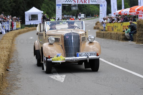 Old beige convertible driving on a road in front of an audience at a classic car race, SOLITUDE REVIVAL 2011, Stuttgart, Baden-Wuerttemberg, Germany, Europe