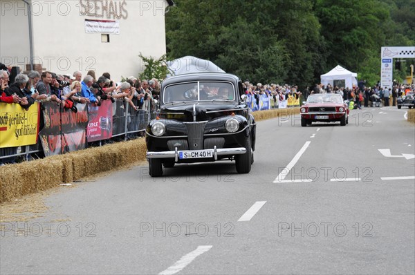 A classic black vintage car drives on a road with a crowd during a rally, SOLITUDE REVIVAL 2011, Stuttgart, Baden-Wuerttemberg, Germany, Europe