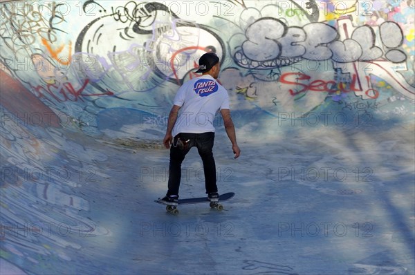 A skateboarder performs tricks in a colourful skate park with graffiti art, Marseille, Departement Bouches-du-Rhone, Provence-Alpes-Cote d'Azur region, France, Europe