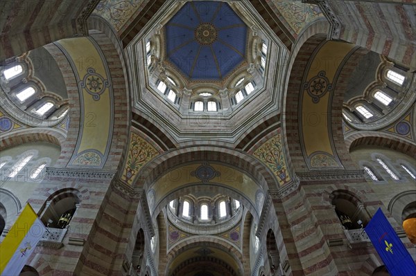 Marseille Cathedral or Cathedrale Sainte-Marie-Majeure de Marseille, 1852-1896, Marseille, View through the nave of a church with pews and various flags on the pillars, view upwards into the dome of a church building with symmetrical ceiling decoration, Marseille, Departement Bouches du Rhone, Region Provence Alpes Cote d'Azur, France, Europe