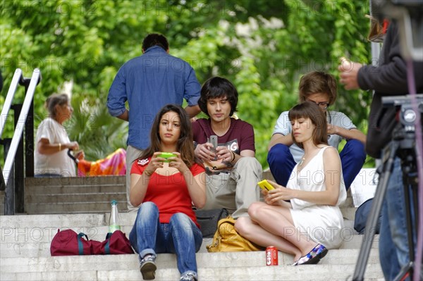 Marseille TV recording, Young people sitting relaxed on stairs and using their smartphones, Marseille, Departement Bouches-du-Rhone, Provence-Alpes-Cote d'Azur region, France, Europe